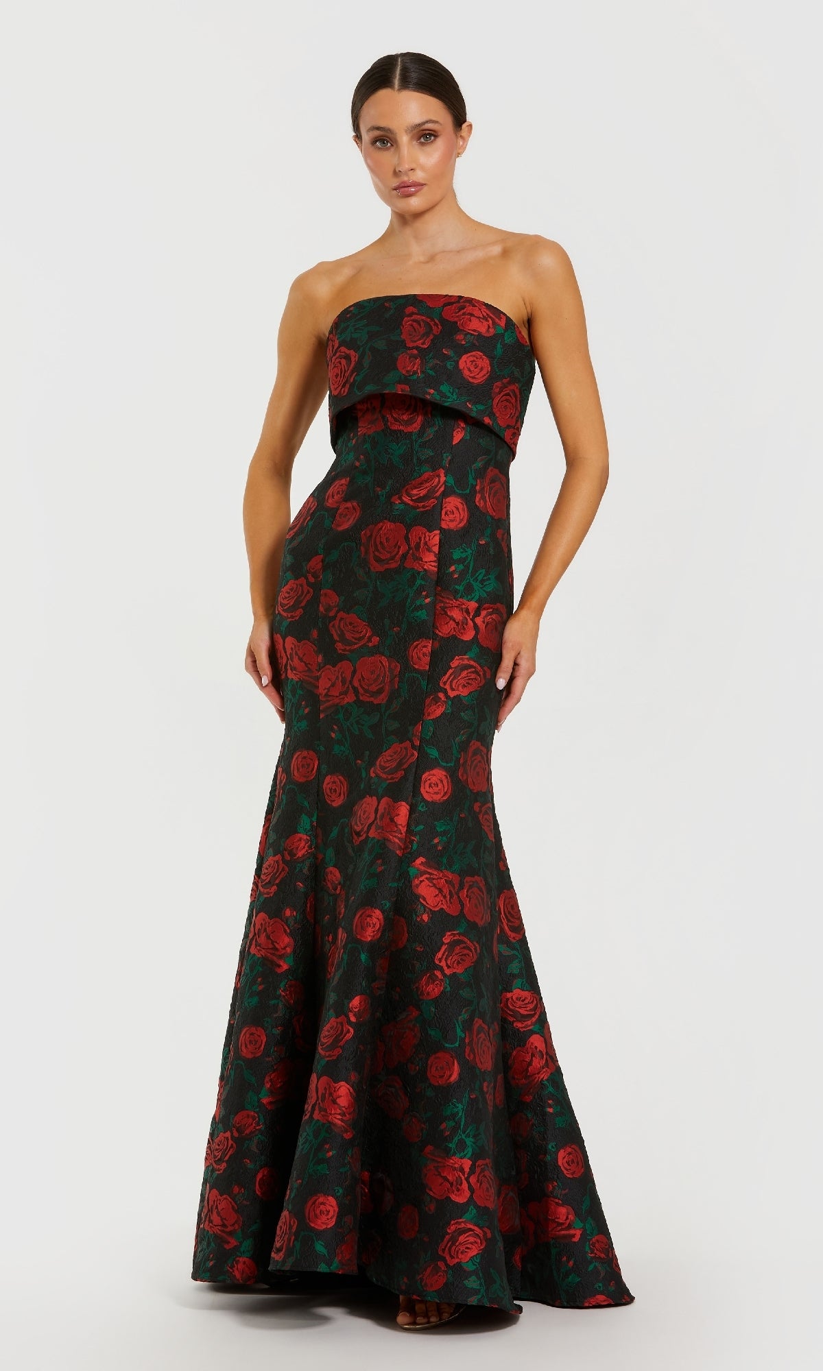 Woman wearing a rose printed mermaid gown with a white background